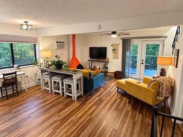 The living room seen from the dining nook, with French doors opening to the deck