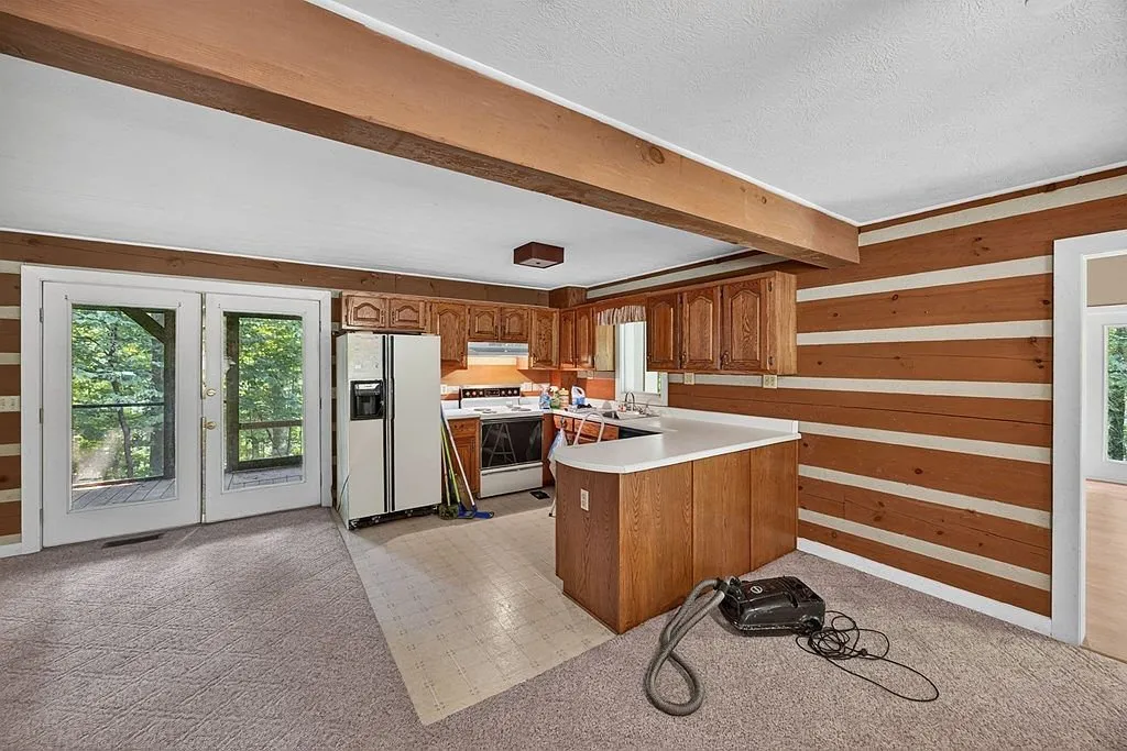 The kitchen with wood cabinets, white appliances and a peninsula counter
