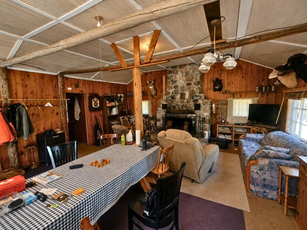 The main room with the long checked table, the fieldstone fireplace and the recliner