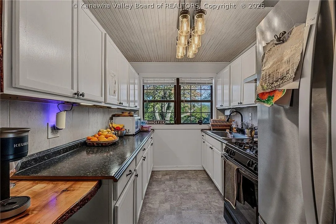 The kitchen counter and cabinets leading toward the back hallway and mudroom
