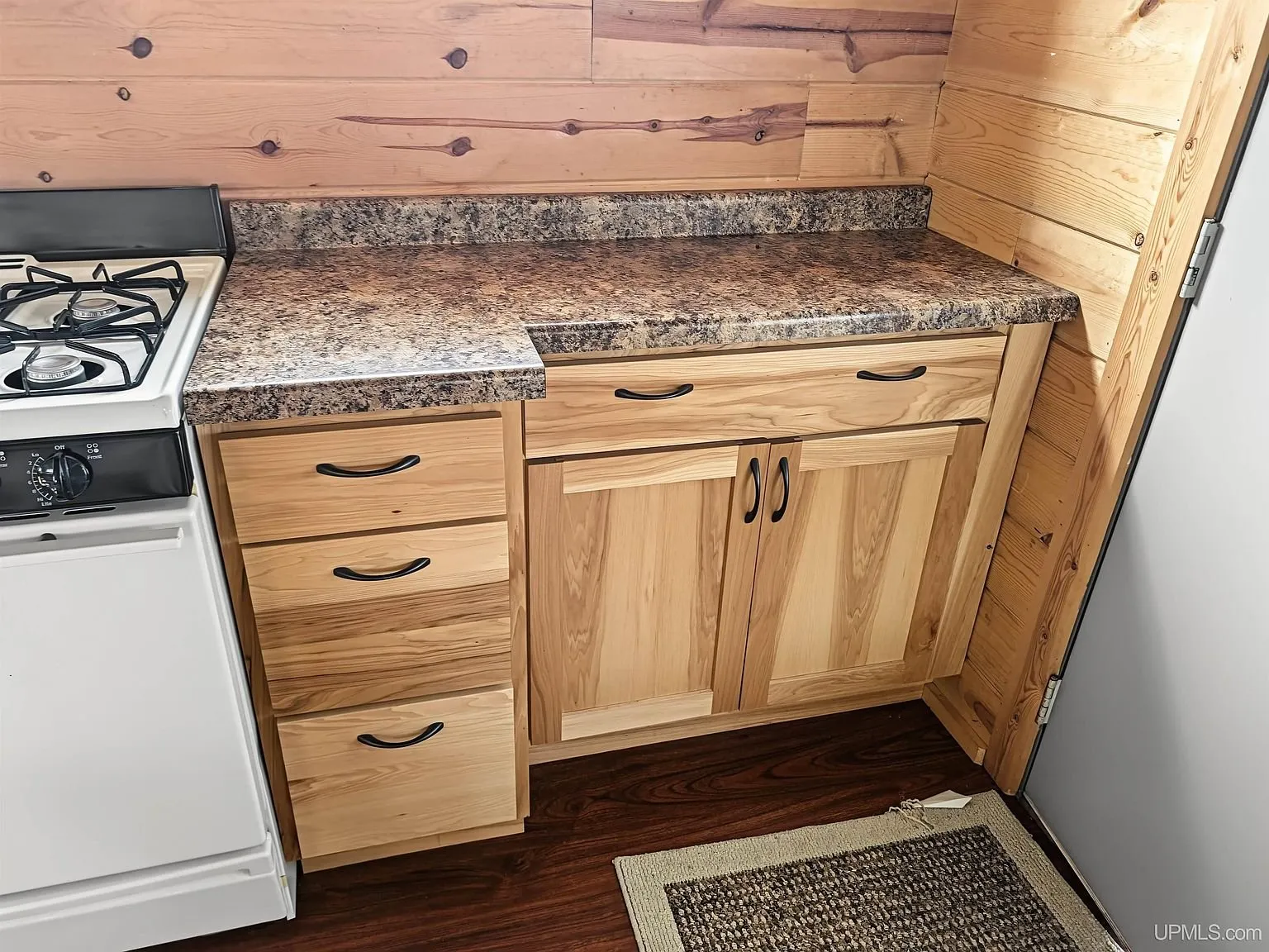 The range, refrigerator and entry door from the kitchen