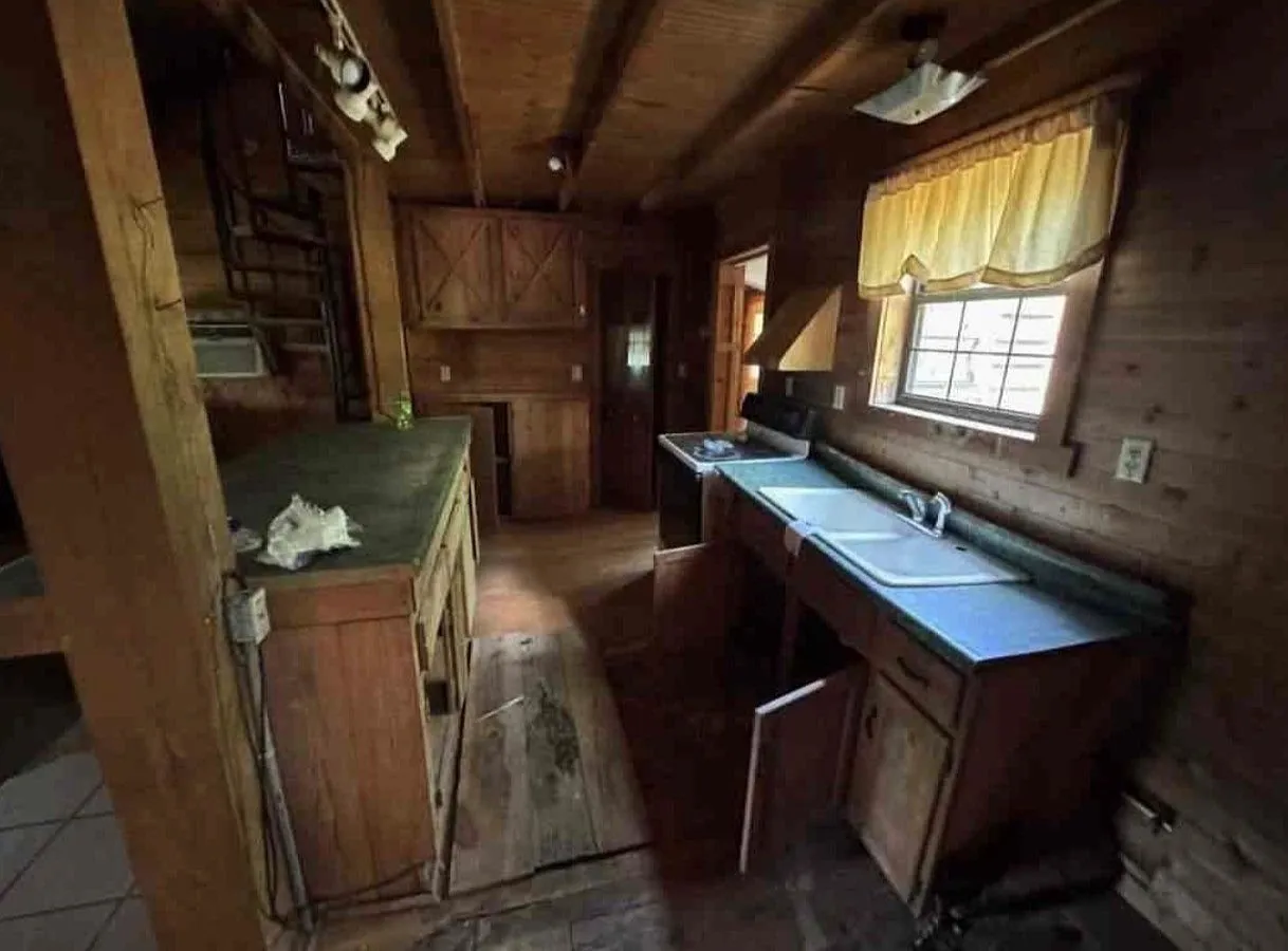 An empty wood-paneled room with a single window