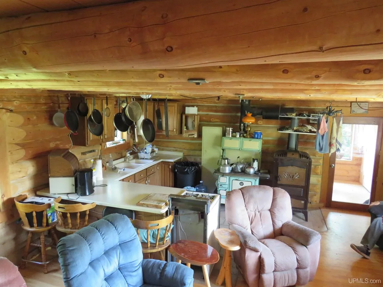 The main room: a table by the window, recliners, and the kitchen along the back wall