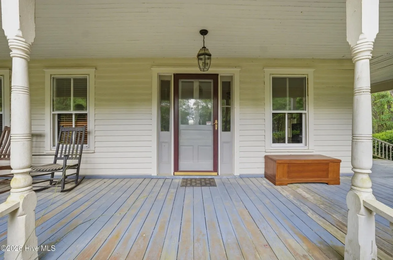 The front porch: painted floorboards, rockers, and the front door with sidelights