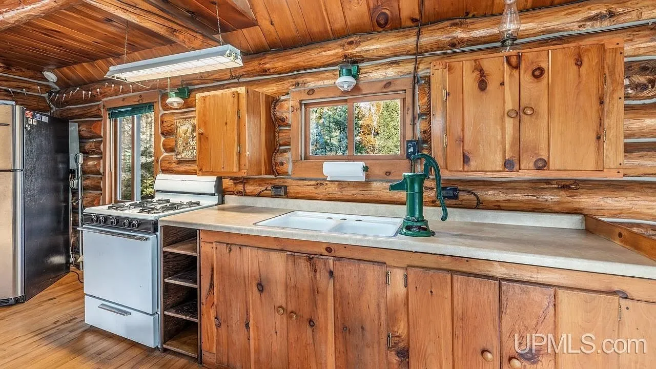 The kitchen counter and cabinets along the log wall