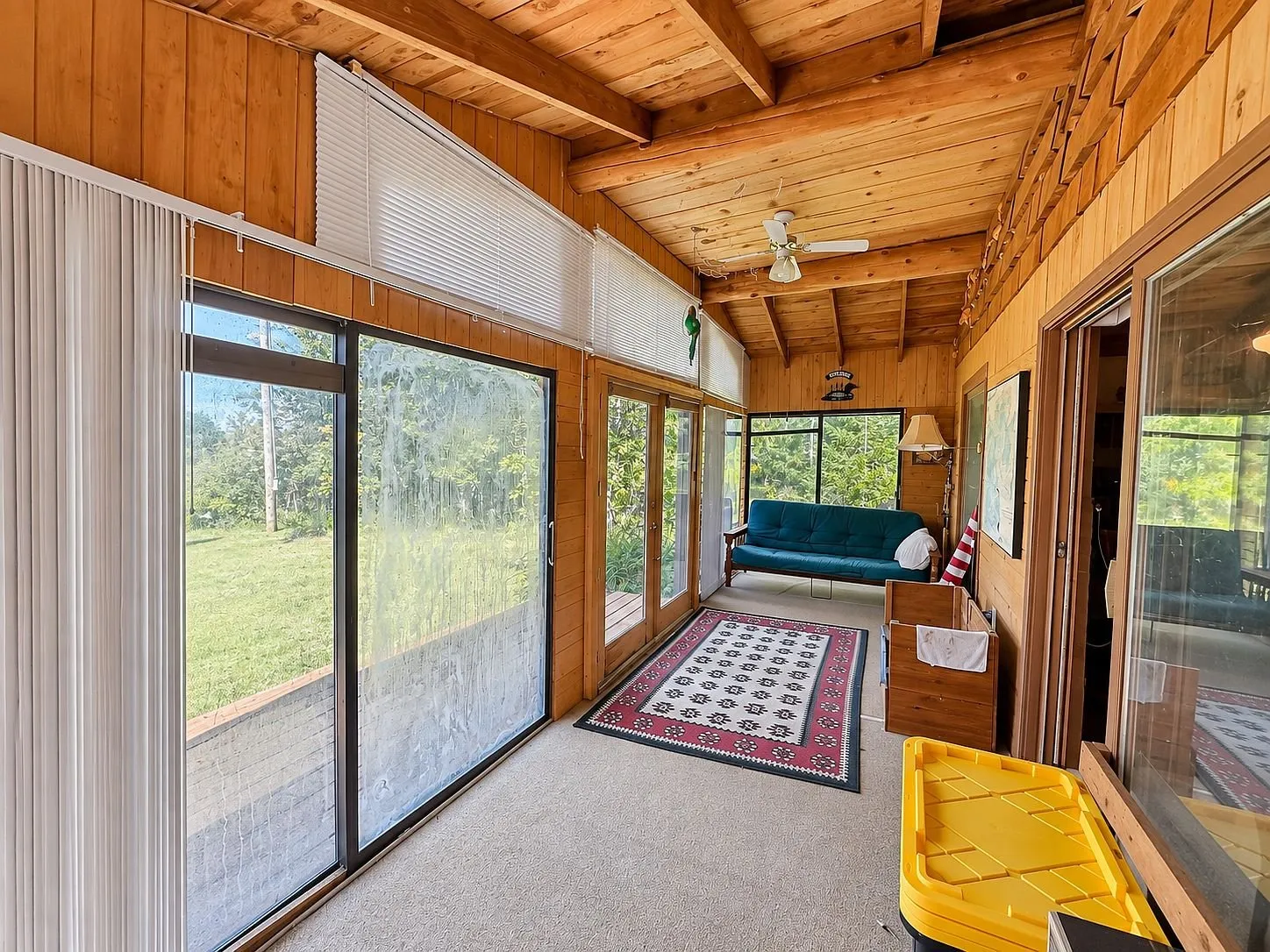 The enclosed porch with its sliding windows and the rug