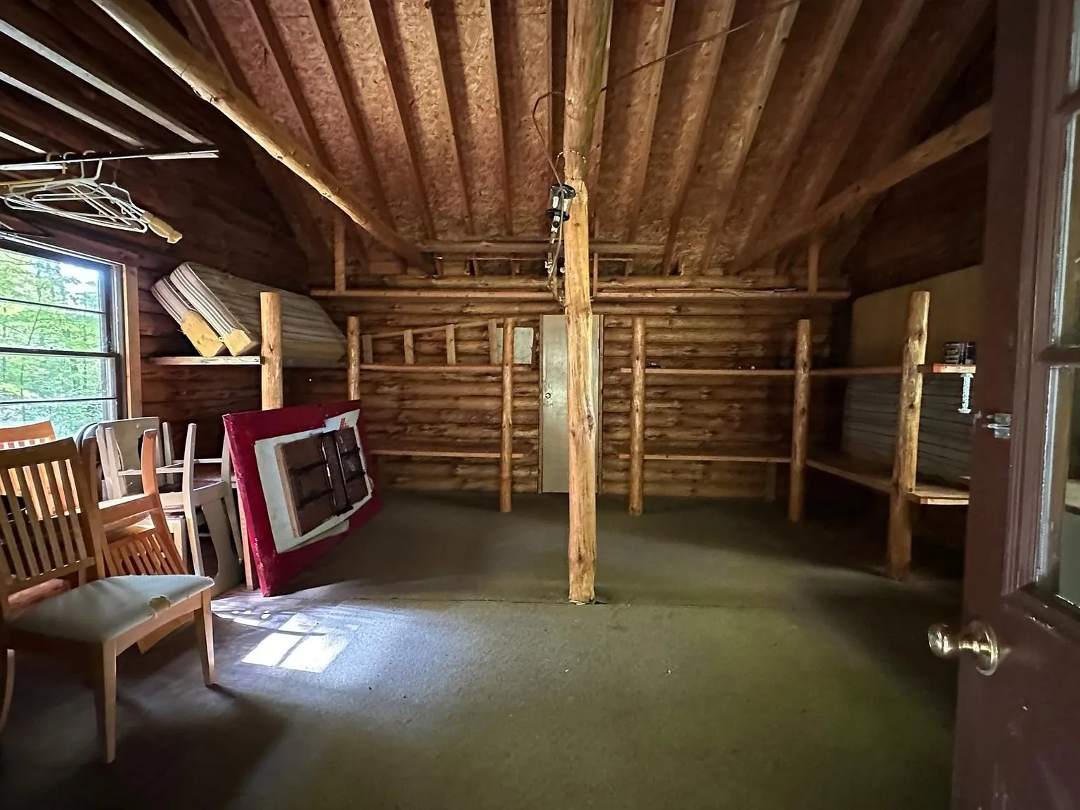 The main room with a bench, mattress and bare log walls