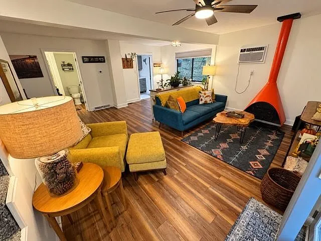 A second living room view with the orange cone fireplace and woven basket storage