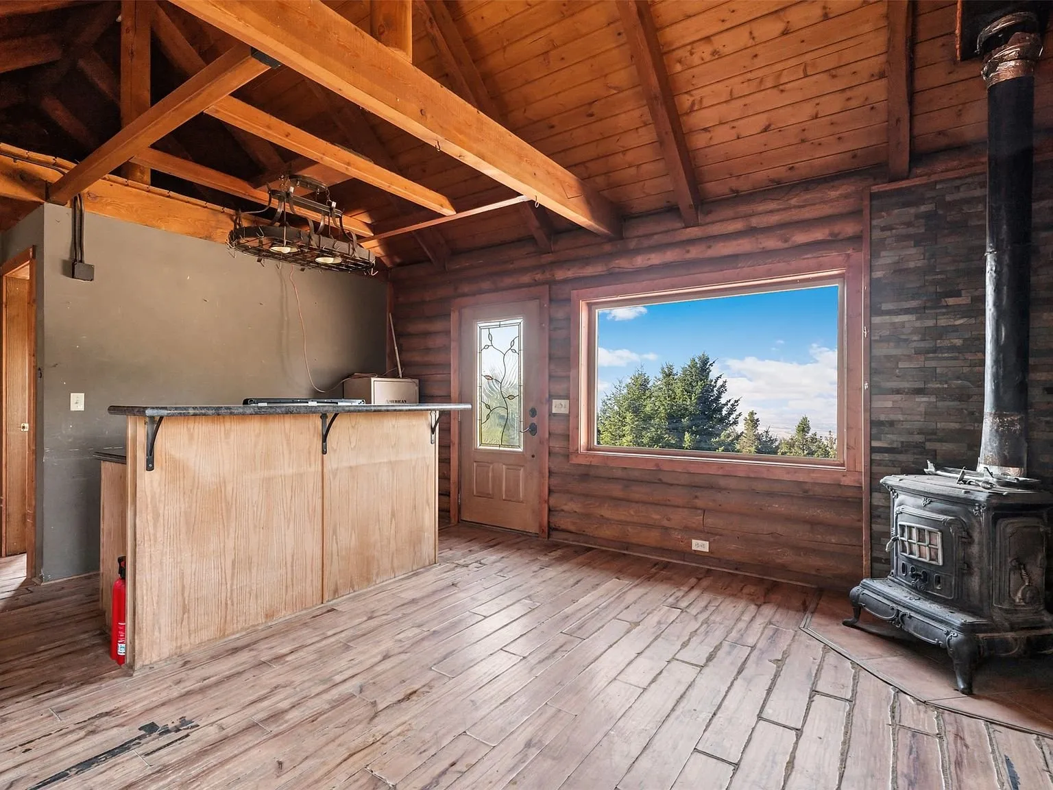 The kitchen area with a gas range, open shelving and stained glass accents in the door