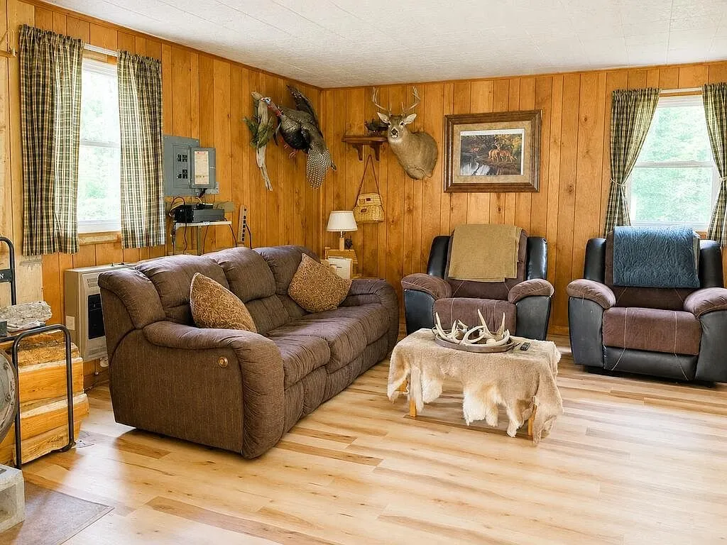 The living room with couches and mounted deer on the pine walls
