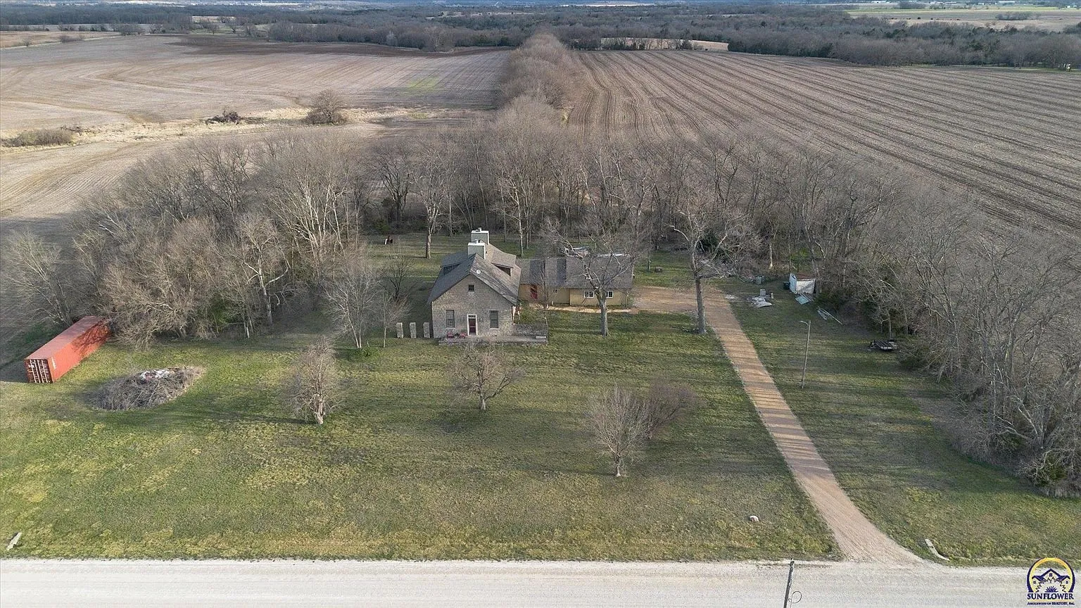 The house and its trees from the air with the fields beyond