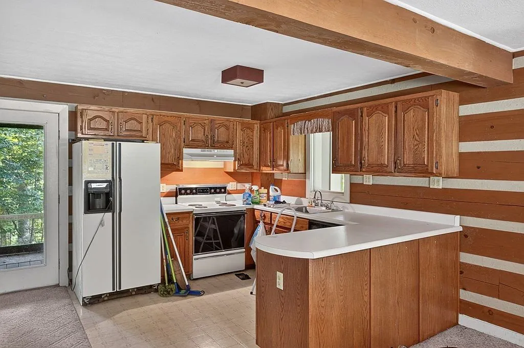 A second view of the kitchen and dining area with log walls