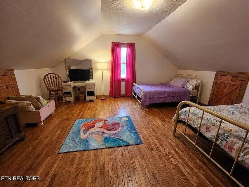 A second upstairs bedroom with two twin beds and a mermaid-themed rug