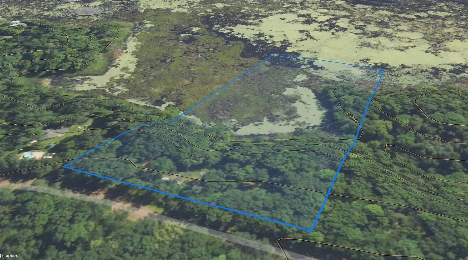 The parcel outlined on an aerial with the road and the marsh