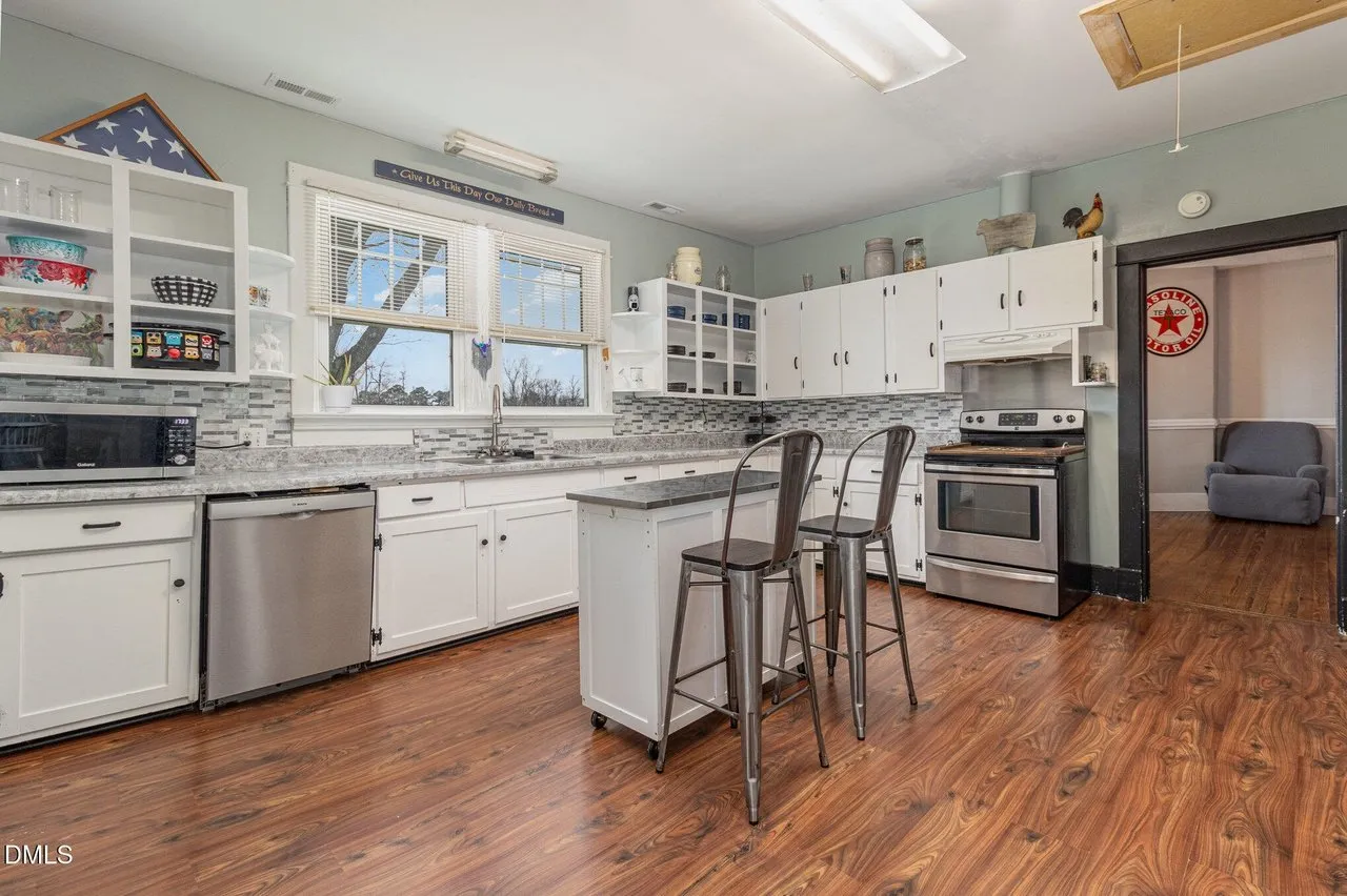 The kitchen from the other end, refrigerator, island and pantry door