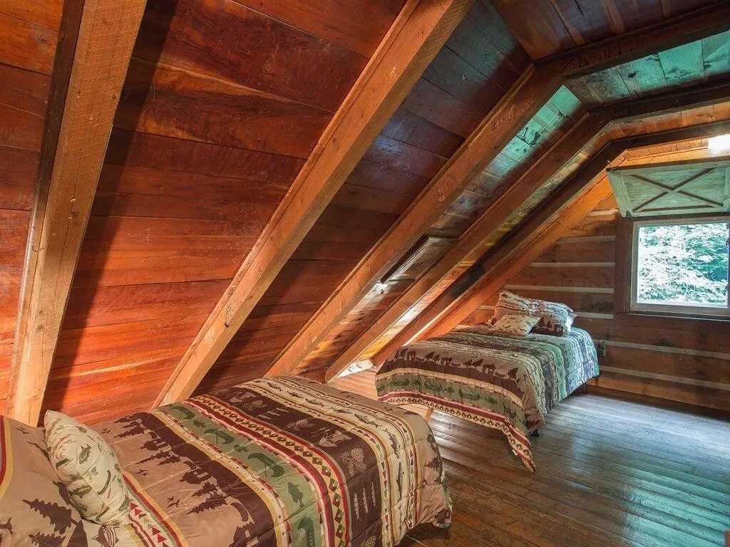 The loft bedroom under the sloped ceiling with a dormer window