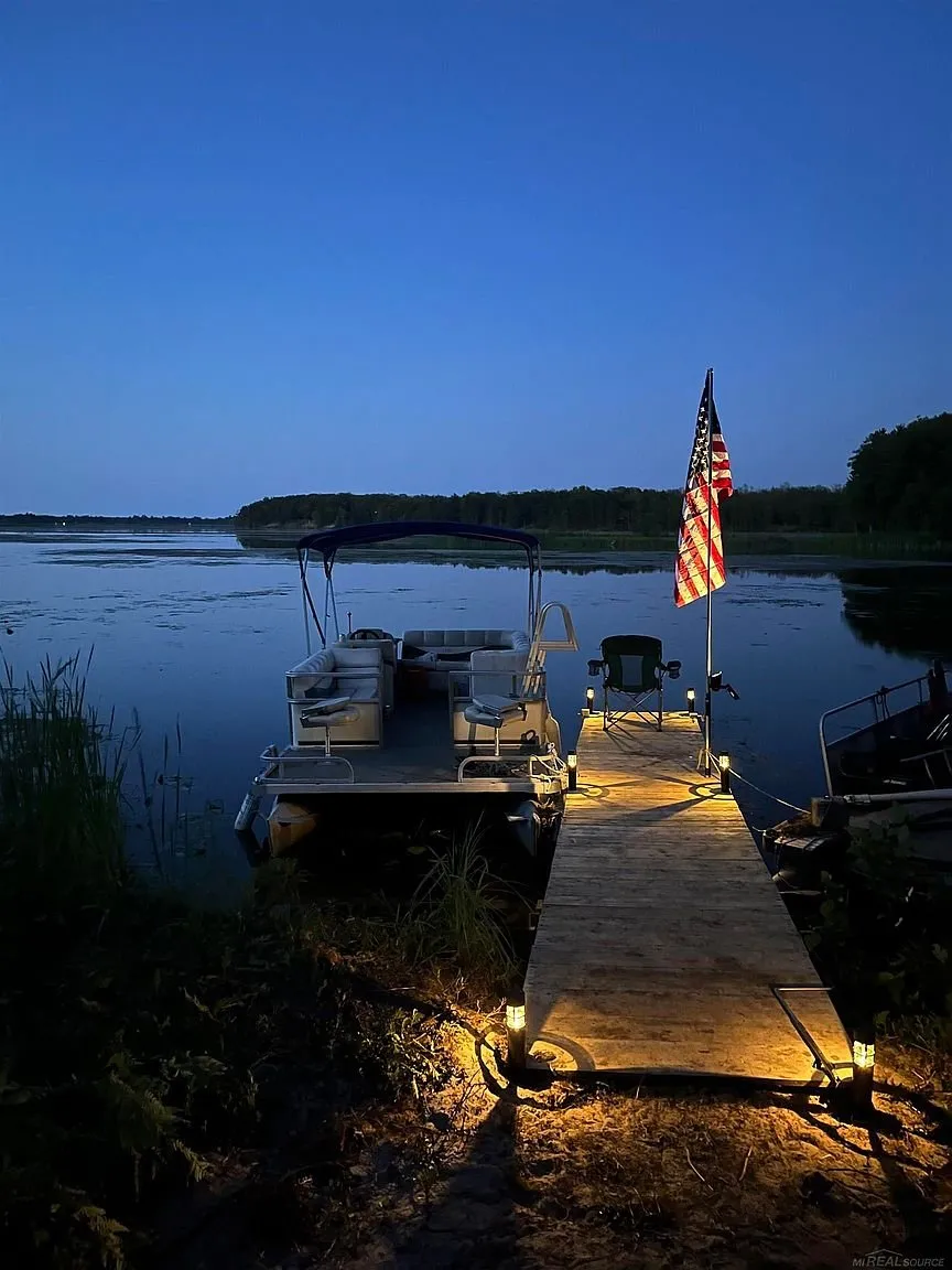 The dock lit at night with the flag and the boat