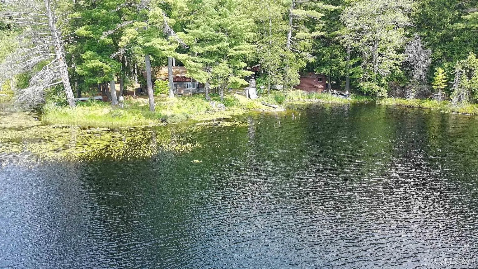 The lake with the cabin and outbuildings on the far shore