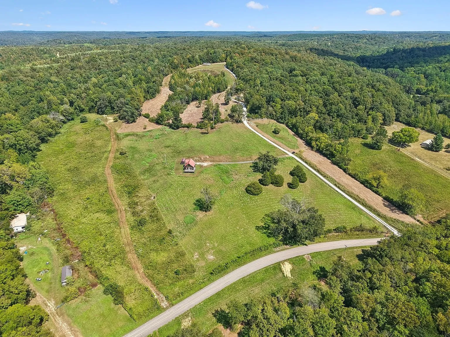 The house and the drive from the air with the road below