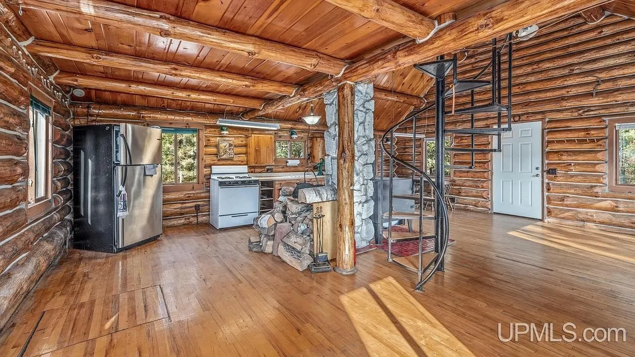 The loft bedroom under the vaulted log ceiling