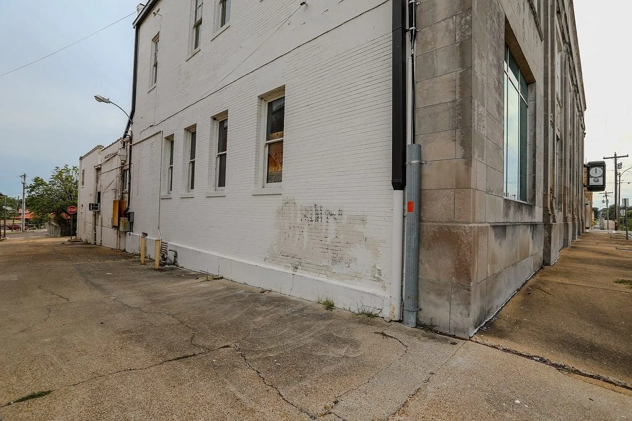The rear corner of the building in painted brick with a security light