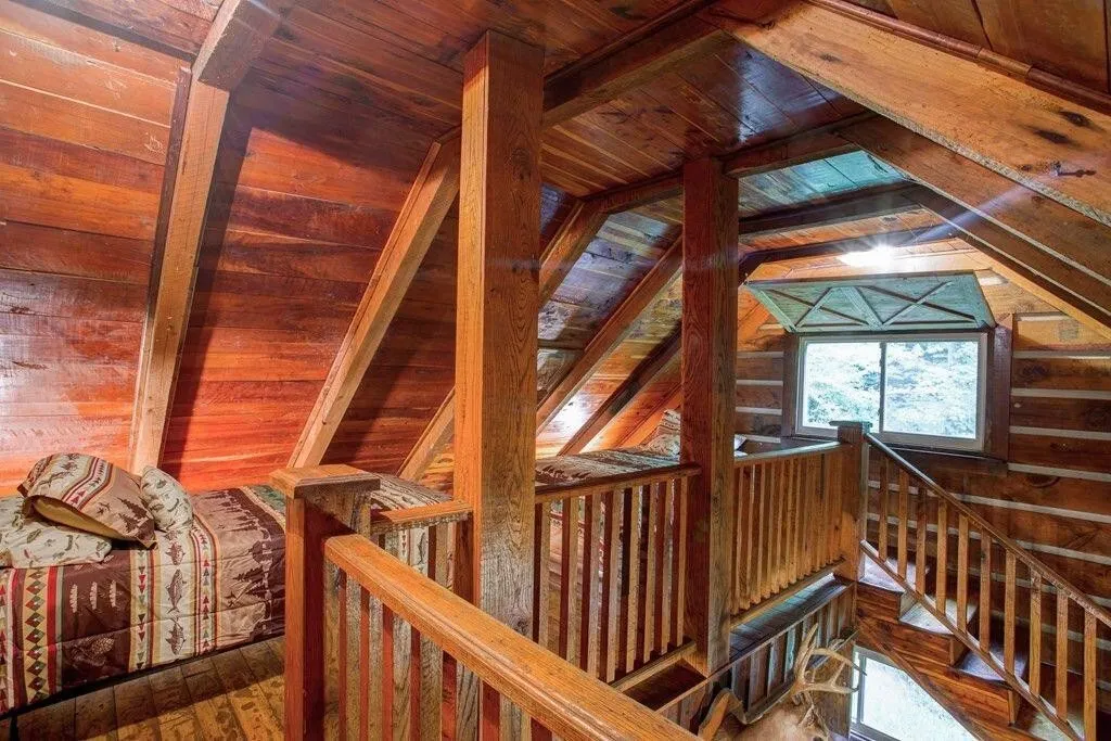 The loft from the top of the stairs, railing overlooking the main room