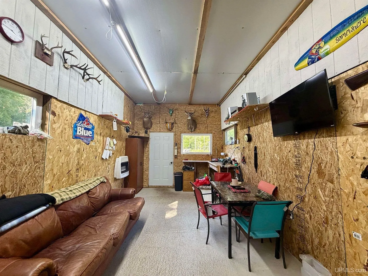 Inside the base camp with the leather sofas, the table and the mounts on the wall