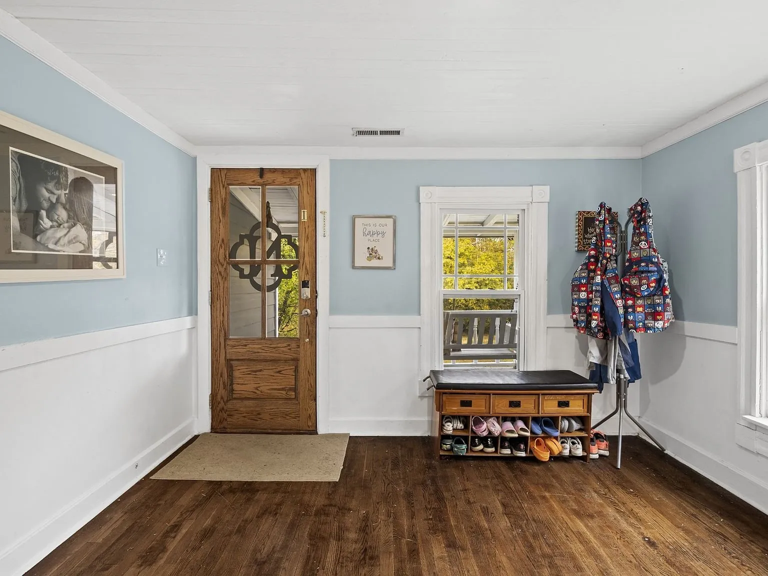 Entry with the wood front door, wainscoting, and wood floors