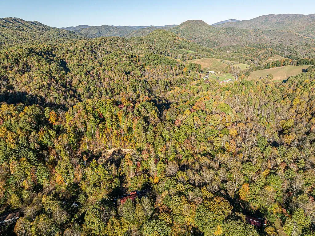 An aerial view of forested ridgelines and farmland near the property