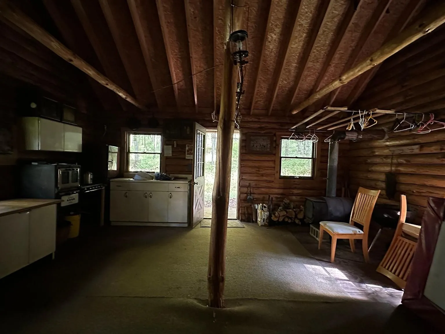 The open room with chairs by the window and the kitchen along the wall