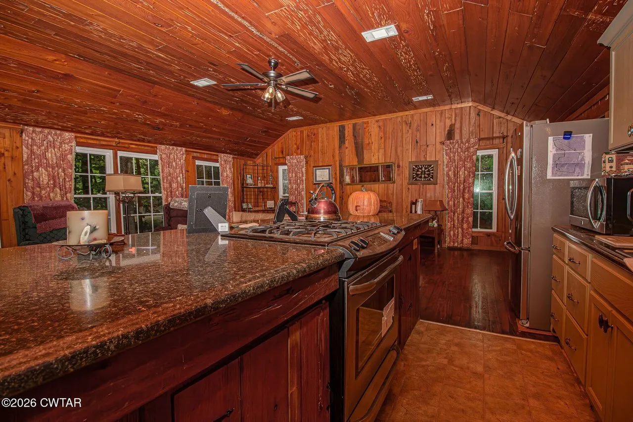 The kitchen with granite counters, stainless range and refrigerator