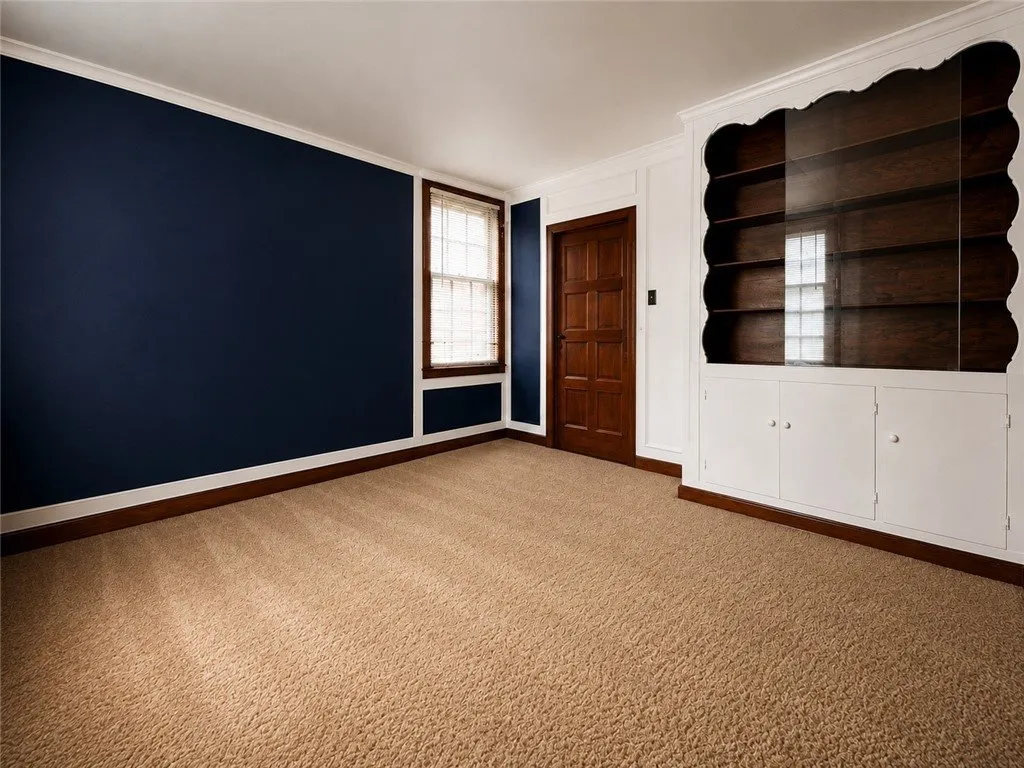 The den with navy walls and a built-in bookcase
