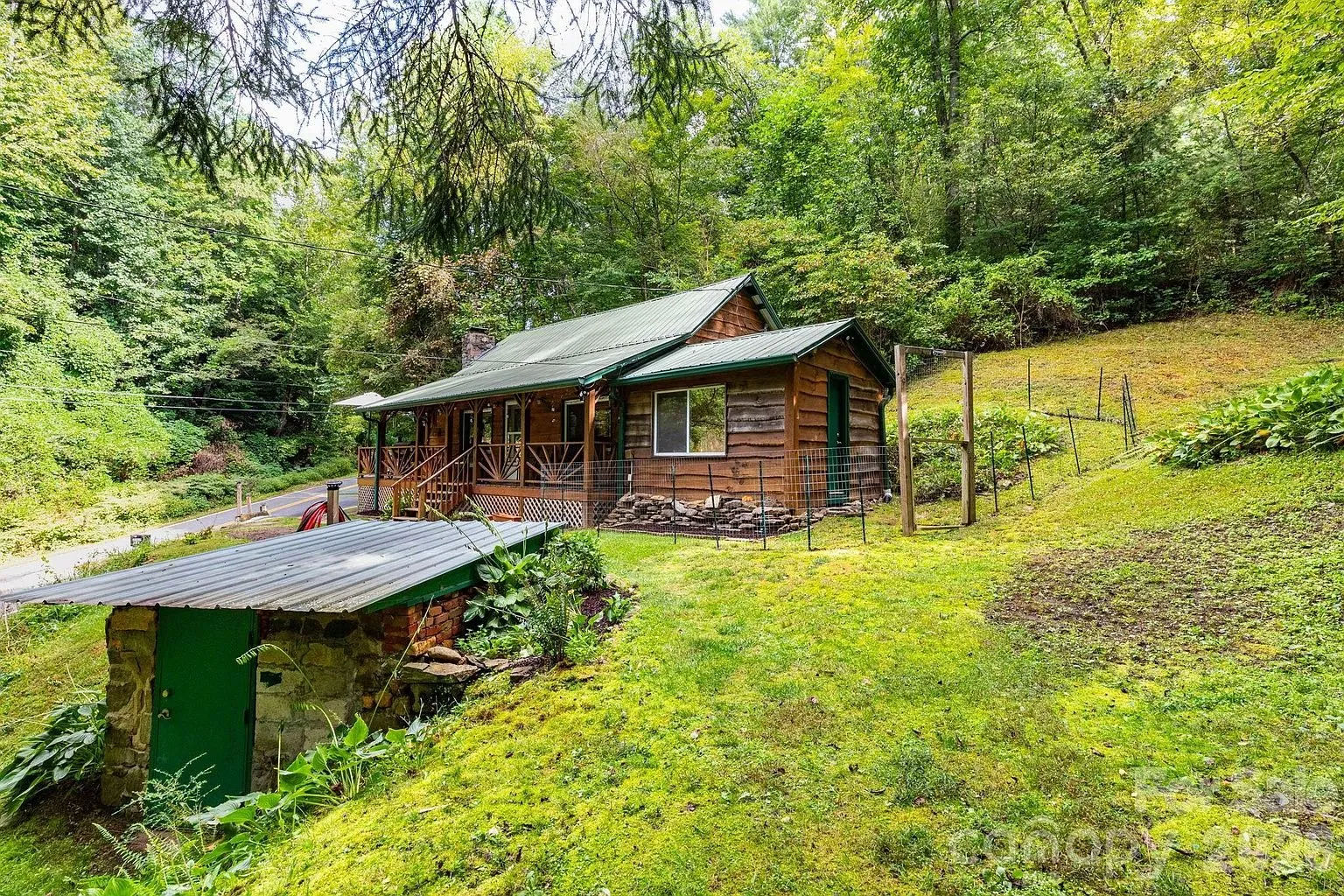 The cottage from the lower yard with a green shed at the bottom