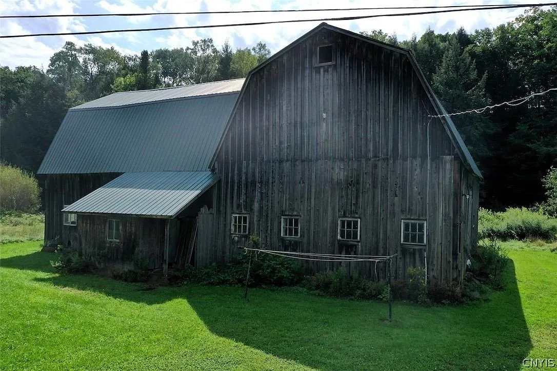 The post-and-beam barn with its metal roof and the lean-to