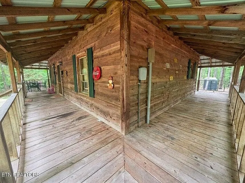 The wraparound porch corner with a Coca-Cola sign and porch seating in the distance