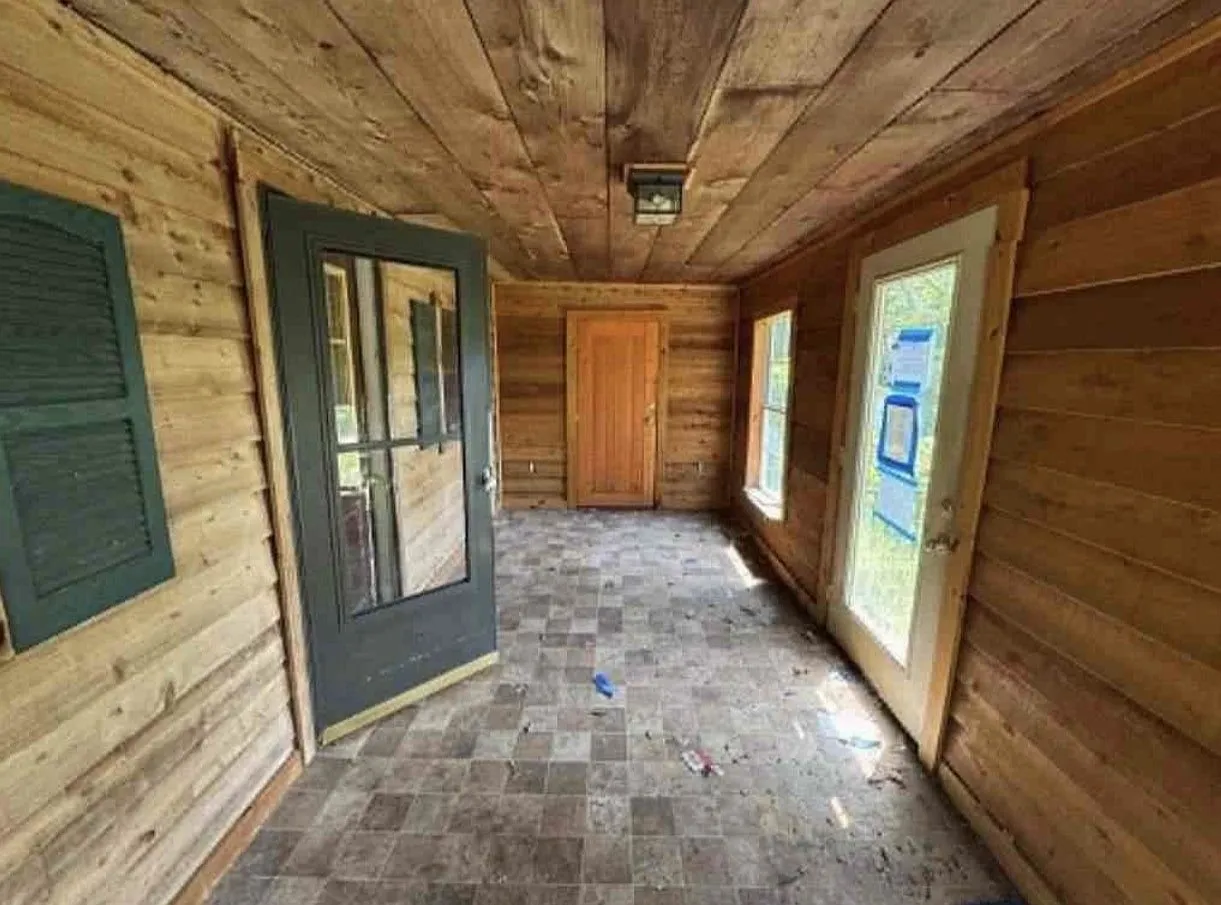 A second wood-paneled room with built-in shelving and a window