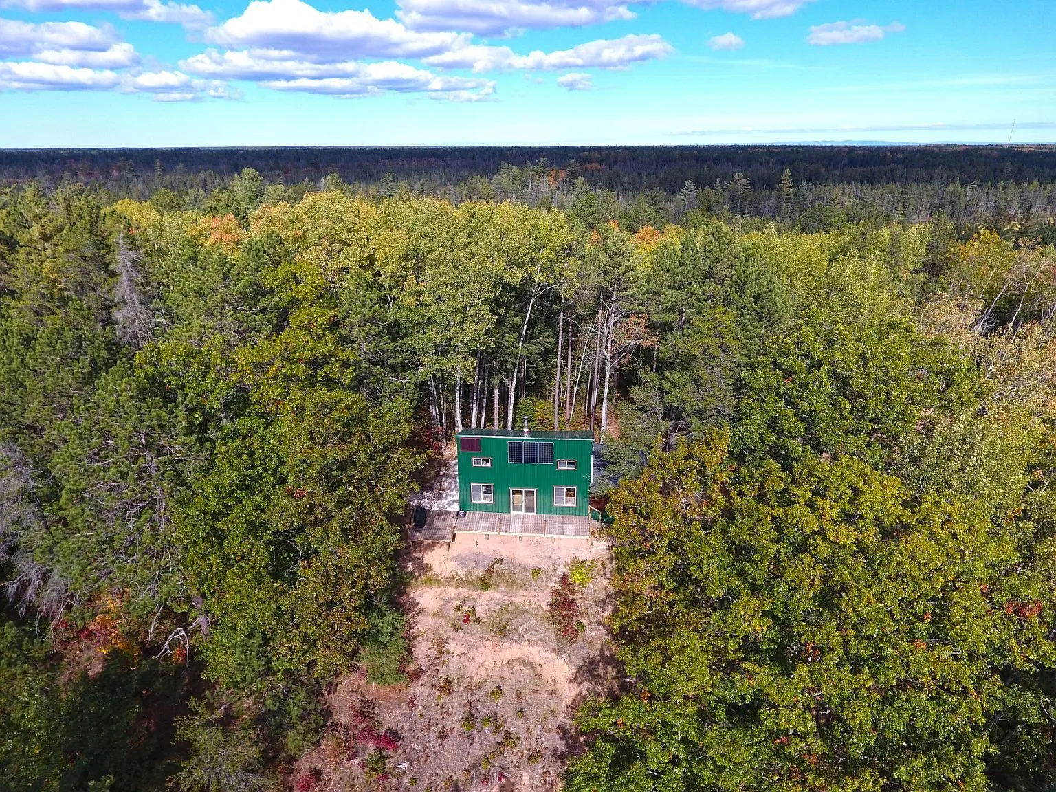 Aerial straight down on the cabin and its clearing in the forest