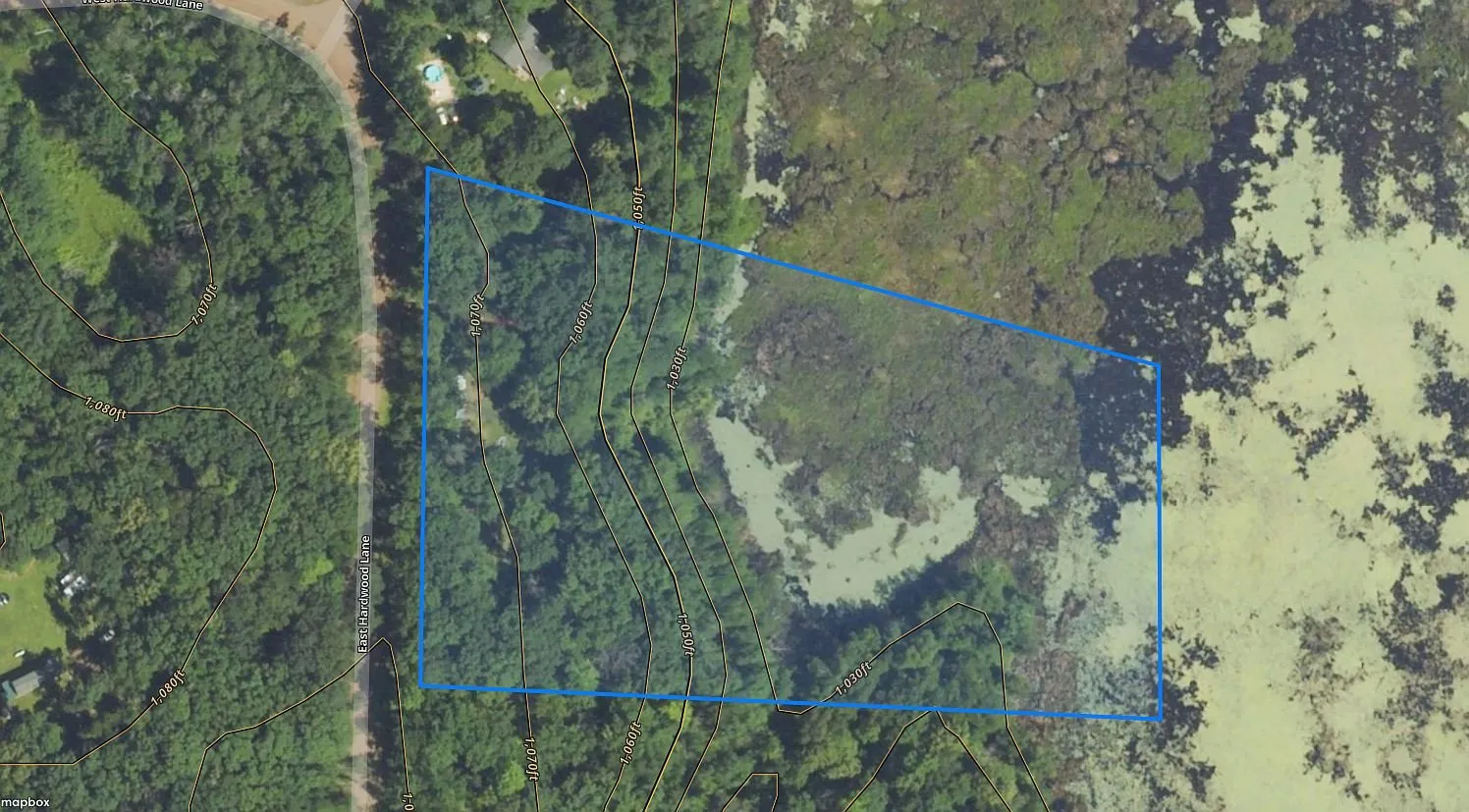 The parcel outlined on an aerial with the road along the south side