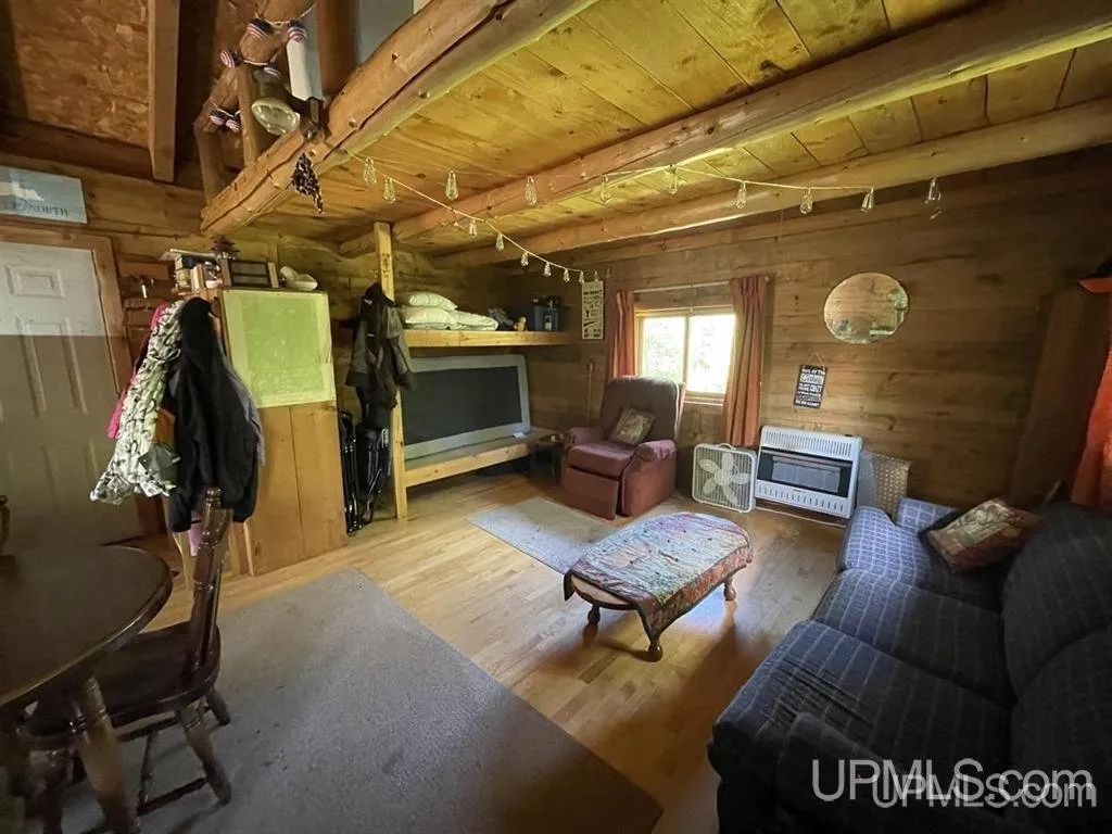 The cabin interior with bunks, coats on hooks and a microwave