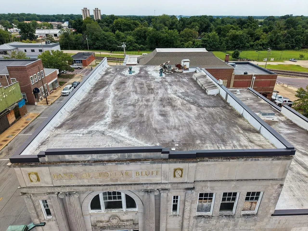 Aerial of the flat roof from the front, Bank of Poplar Bluff lettered on the parapet