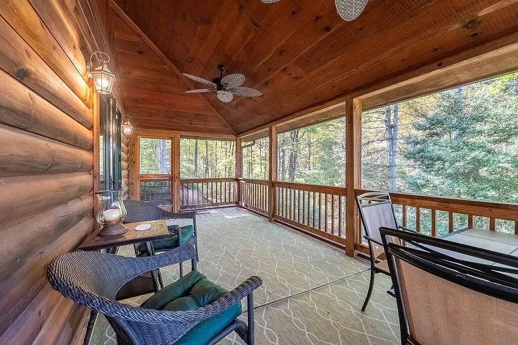 The screened porch with ceiling fans and patio furniture