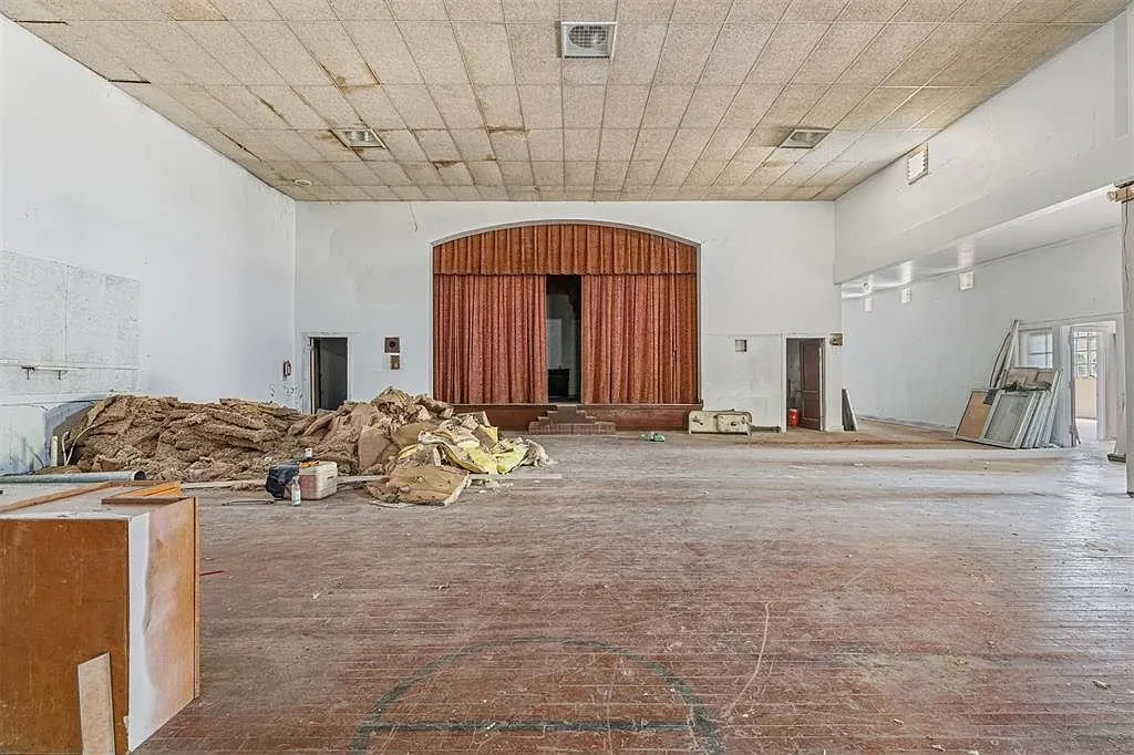 The stage with its wooden proscenium and curtain and the debris pile in front