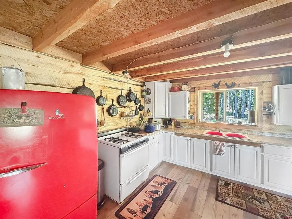 The red refrigerator and the range with the white cabinets