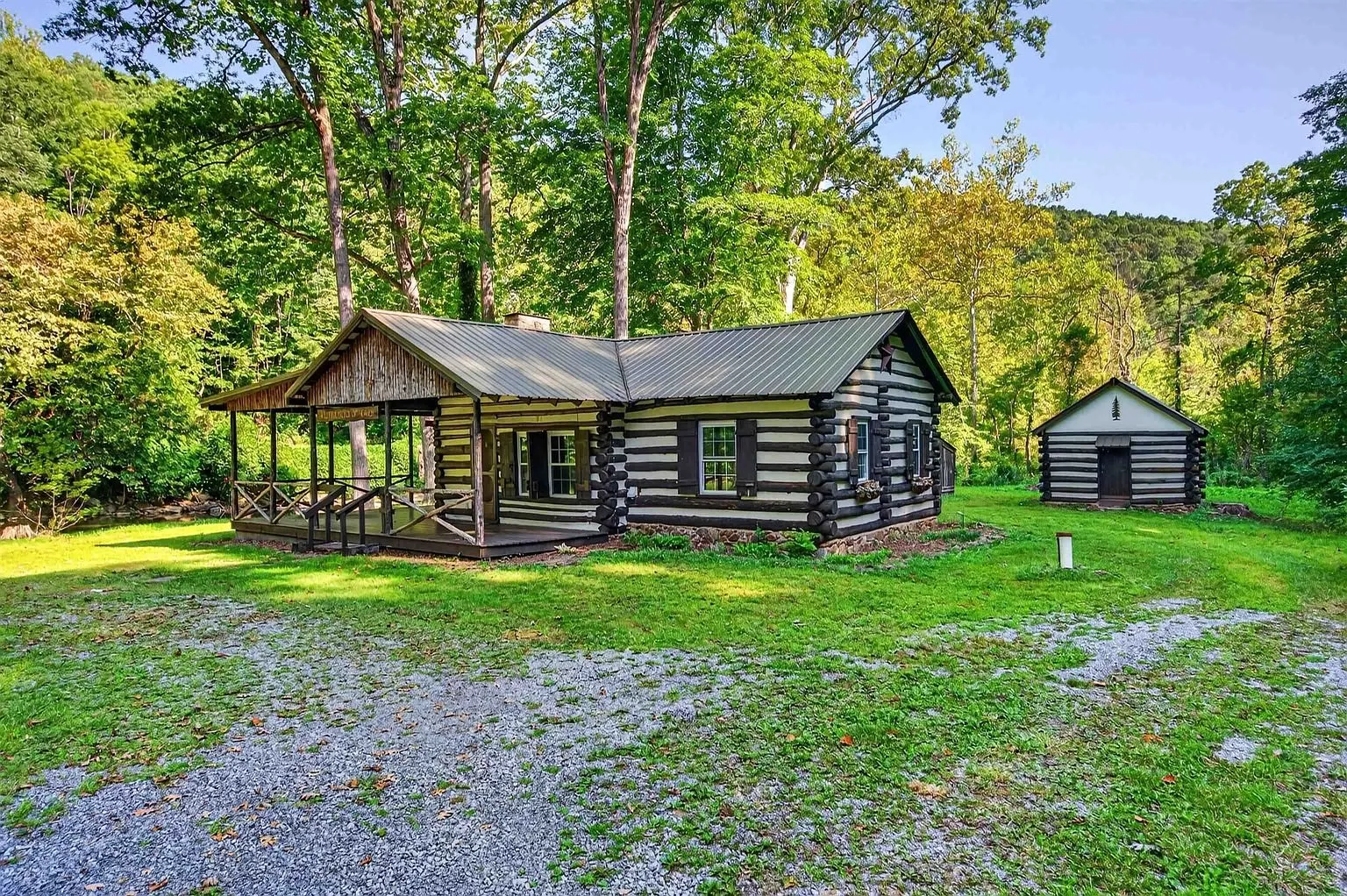 The cabin with the log outbuildings behind it