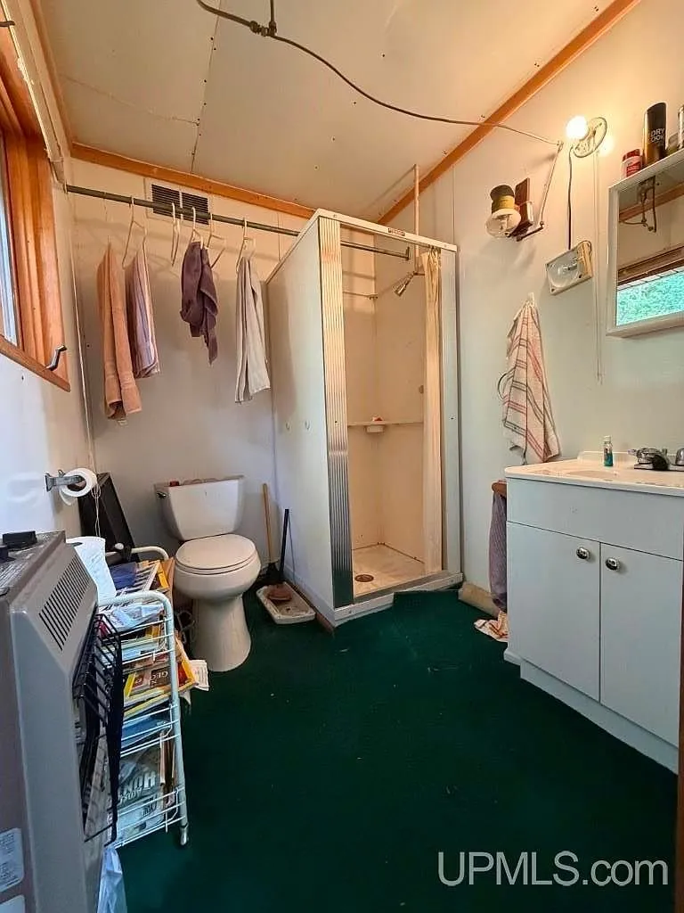 The bathroom with a vanity, toilet and shower