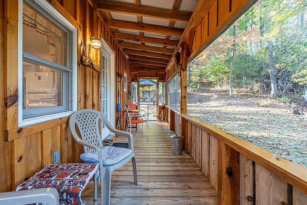 The covered side porch with plastic chairs and a view into the screened porch
