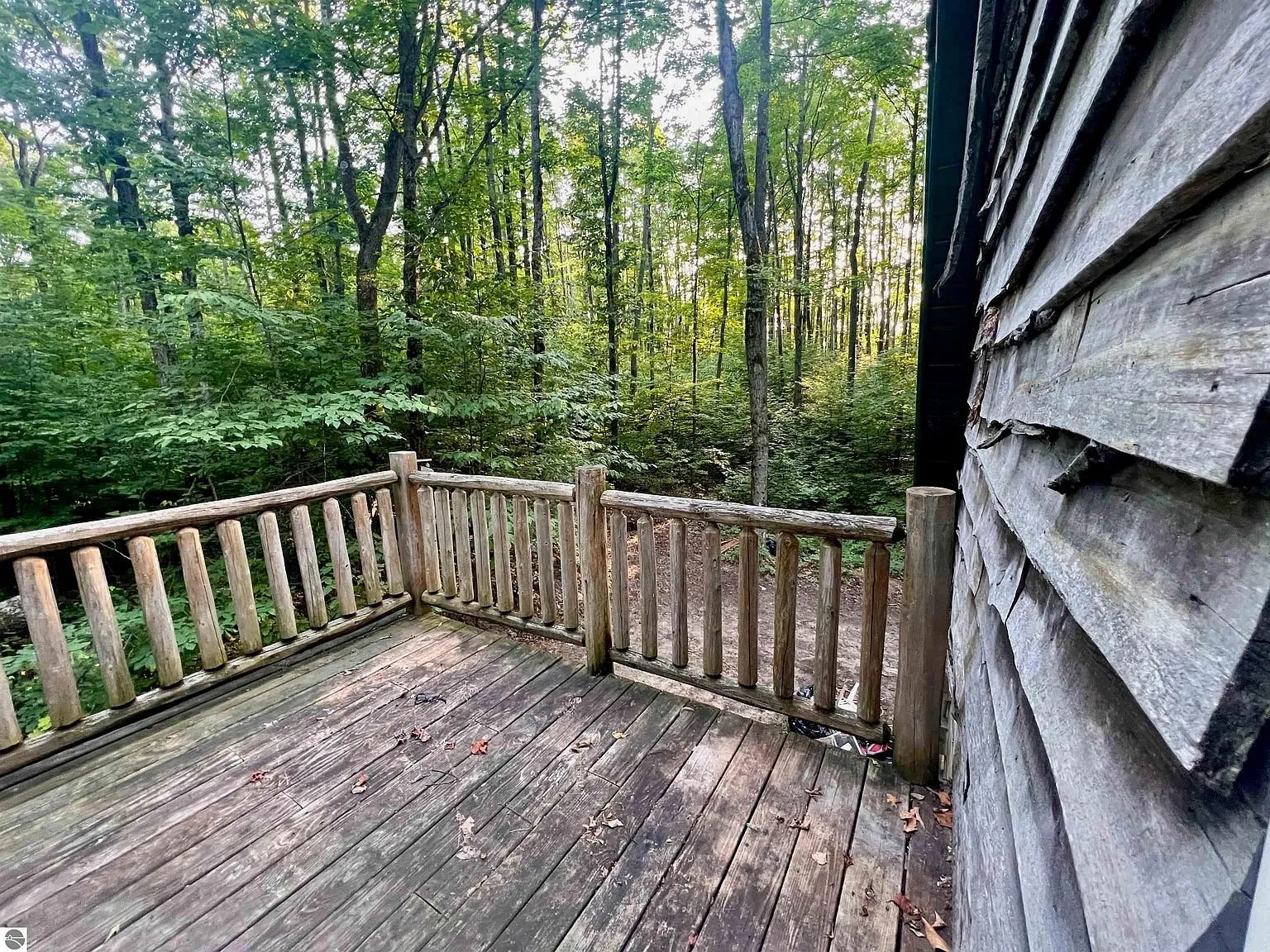 A balcony with its log rail against the shake wall