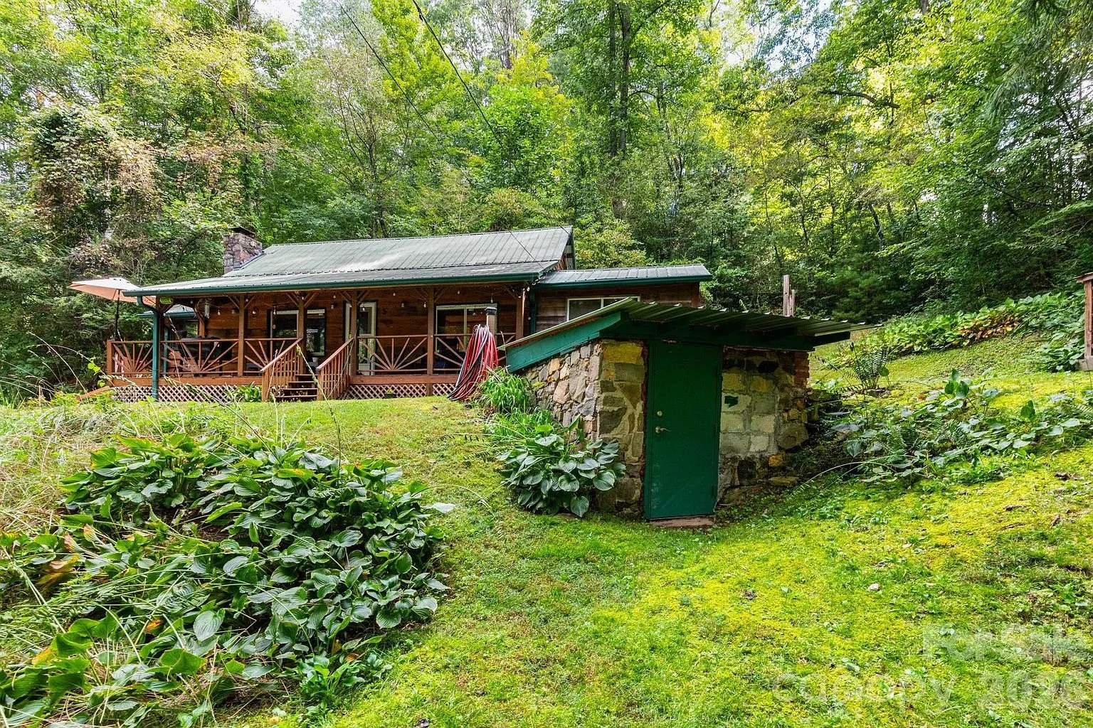 The shed built into the bank with a green door