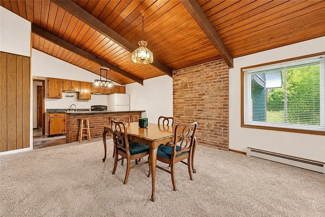 The kitchen with the breakfast bar and brick accent wall