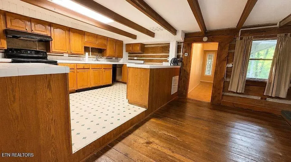 The kitchen island, range and the log wall beyond